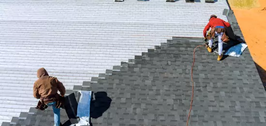 Workers for Schneider Construction installing shingles on a residential roof in Central Illinois