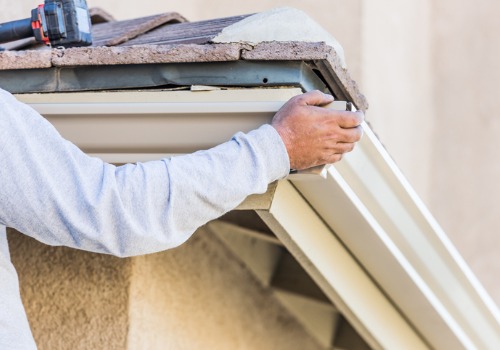 Professional affixing new Gutters to the side of a roof in Peoria IL