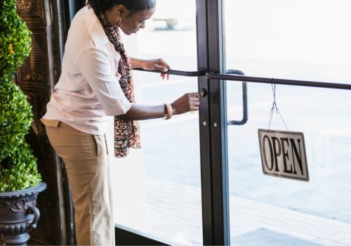 A woman changing the sign on a new commercial door in Peoria IL